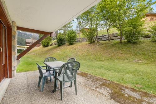 a table and chairs on the porch of a house at Charmant 2,5 pièces au pied des Bains d'Ovronnaz in Ovronnaz