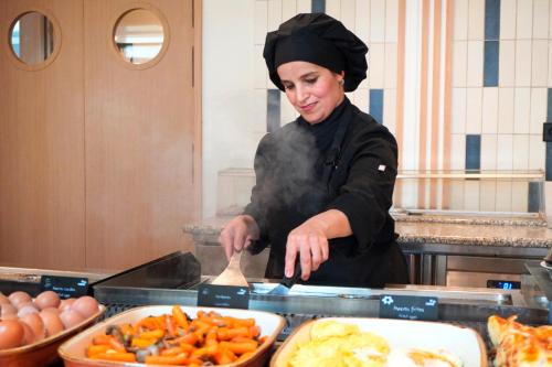 una donna che cucina cibo in una cucina con fumo di HSM Lago Park a Playa de Muro