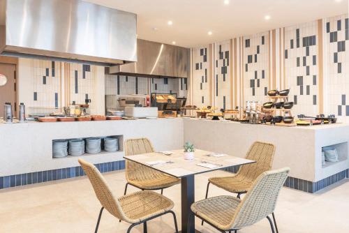 una sala da pranzo con tavolo e sedie e una cucina di HSM Lago Park a Playa de Muro