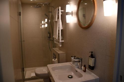 a bathroom with a sink and a toilet and a mirror at Hôtel Casimir in Paris