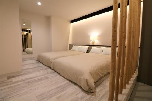 a bedroom with a large bed with white sheets at Smart Stay Ito 302 - Vacation STAY 98471 in Ito