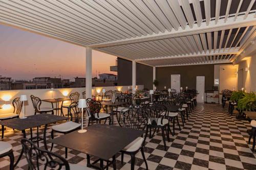 a restaurant with tables and chairs on a roof at The Oscar Olympic Hotel in Thessaloniki