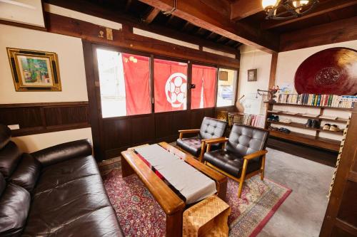 a living room with a leather couch and chairs at Chikugo Yoshii Guest House IKUHA - Vacation STAY 00074v in Ukiha