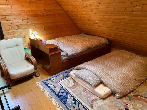 a room with two beds and a chair in a cabin at Ise Forest villa - Vacation STAY 9557 in Ise