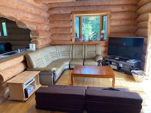a living room with a couch and a tv in a log cabin at Ise Forest villa - Vacation STAY 9557 in Ise