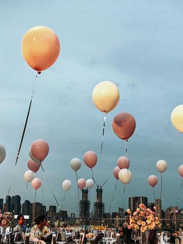 a bunch of balloons flying in the sky at Grand Madison Wuhan Hankou on the Bund in Wuhan