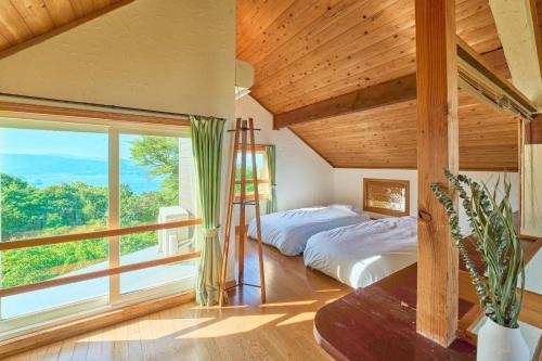 a bedroom with a bed and a large window at Oceanic House TAMATEBAKO - Vacation STAY 98444 in Ito
