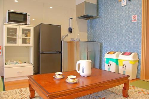 a kitchen with a wooden table and a refrigerator at Guest House Orange no Kaze - Vacation STAY 01298v in Imabari