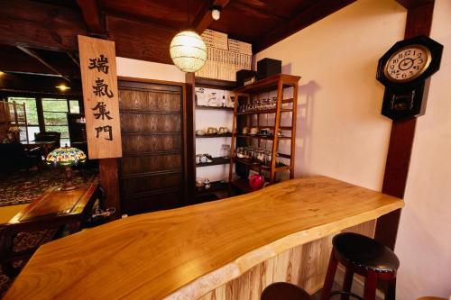 a bar in a restaurant with a clock on the wall at Chikugo Yoshii Guest House IKUHA - Vacation STAY 00064v in Ukiha