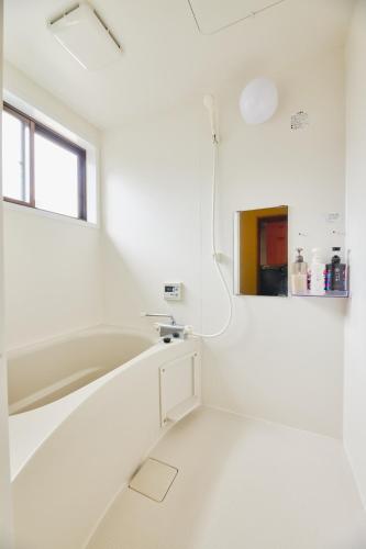 a white bathroom with a tub and a sink at Chikugo Yoshii Guest House IKUHA - Vacation STAY 00077v in Ukiha