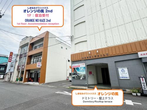 a building with a sign on the side of a street at Guest House Orange no Kaze - Vacation STAY 01295v in Imabari