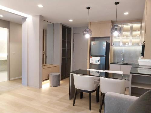 a kitchen with a table and chairs and a refrigerator at The Regent ​Phuket ​Serviced Apartment ​Kamala ​Beach in Kamala Beach