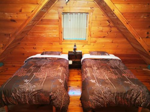 two beds in a room in a log cabin at Nasusanso - Vacation STAY 9643 in Nasu-yumoto