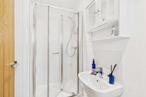 a white bathroom with a shower and a sink at Host & Stay - Bayview Lodge in Beadnell