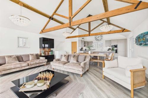 a living room with white furniture and wooden ceilings at Host & Stay - Bayview Lodge in Beadnell