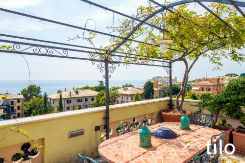 a table on a balcony with a view of the ocean at Villa Aranci | Historical Residence | By Tilo Lux in Genova
