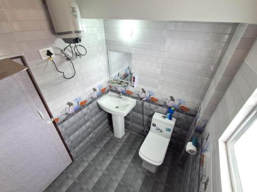 Un baño pequeño con inodoro y lavabo. en Sat Chit Ananda bhavan, en Darjeeling