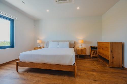 a bedroom with a large white bed and a dresser at 5BR Villa with Pool & Patio at Casa Eloisa by Bocobay in Oranjestad