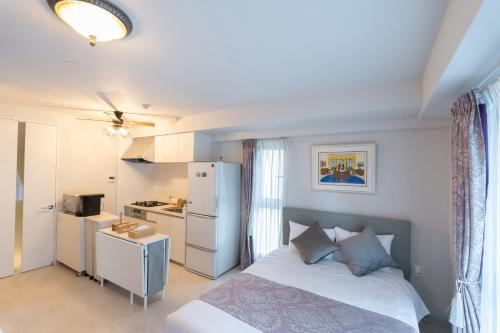 a bedroom with a bed and a small kitchen at Fuchsia - Vacation STAY 78249v in Nagoya