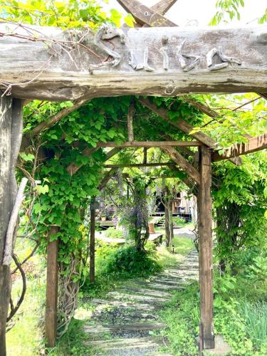 a wooden pergola covered in green ivy at Tida House - Vacation STAY 07404v in Koshimizu-shigai