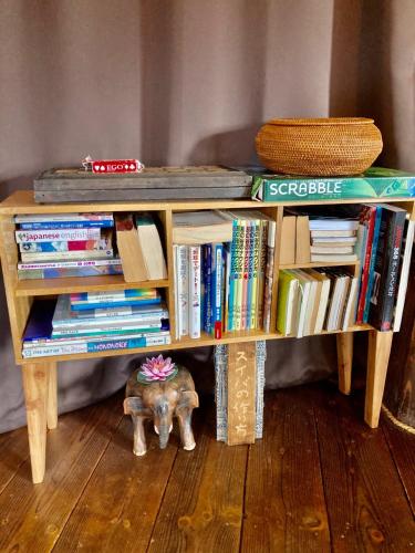 a book shelf with books and an elephant under it at Tida House - Vacation STAY 07404v in Koshimizu-shigai