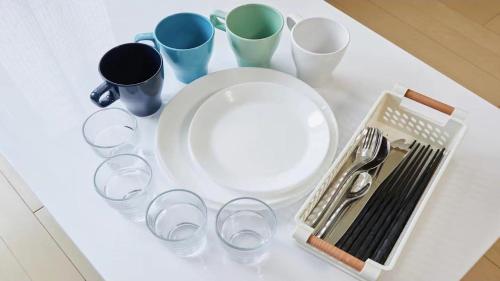 a table with a plate and some cups and utensils at Marvelous Higashioi - Vacation STAY 13015v in Tokyo