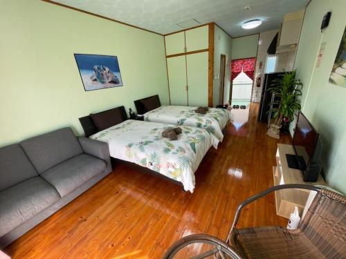 名户NAGO Sakura Resort Inn - Vacation STAY 14447v的有两张床和一张沙发的客厅