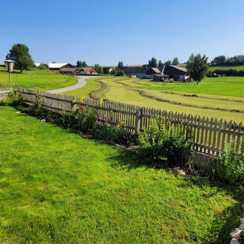a wooden fence in a field with a road at Landhaus auf der Alm in Langschlag