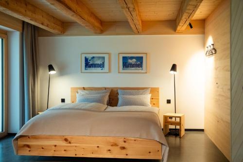 a bedroom with a large bed and two lamps at HEIMATEL - A Huesle in Oberreute