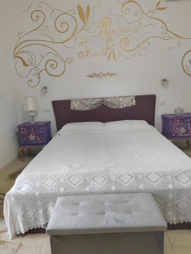 a bedroom with a bed with a white comforter at Giardino Principi Dafagi in Capurso