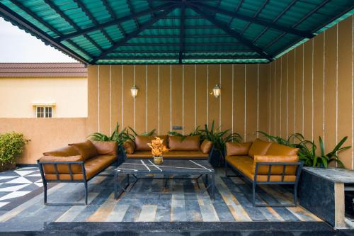 a patio with two couches and a coffee table at The Bliss Hushwood 2-BHK Villa With Private Pool, Lush Garden & Poolside Gazebo Pet-friendly in Udaipur