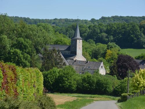 an old church with a steeple on a hill at Beautiful Ardennes house in quiet area in Sainte-Ode
