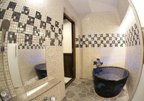a bathroom with a black tub and a mirror at Hidatakayama Ukiyoe INN Garon - Vacation STAY 12320v in Takayama