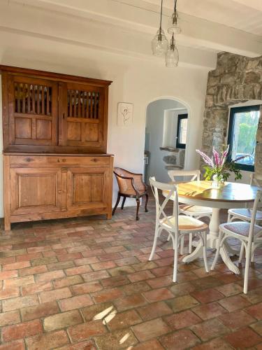 a dining room with a table and a table and chairs at Les Herbes Blanches - Gîte privé - calme & nature, rivière in Grospierres