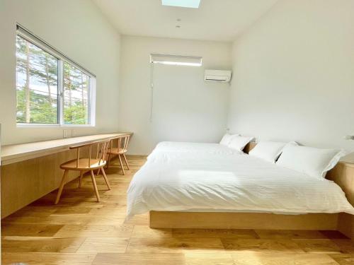 una camera da letto con un letto, una scrivania e una finestra di Karuizawa House Villa - Vacation STAY 16963v a Oiwake