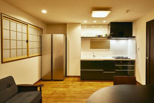 a kitchen with a refrigerator and a table in a room at 634 Condo Yotsuya - Vacation STAY 14799v in Tokyo