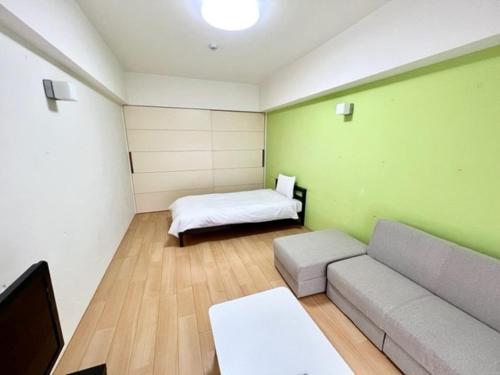 a living room with a couch and a bed at Hamamoto Palace Taniyama - Vacation STAY 11966 in Kagoshima