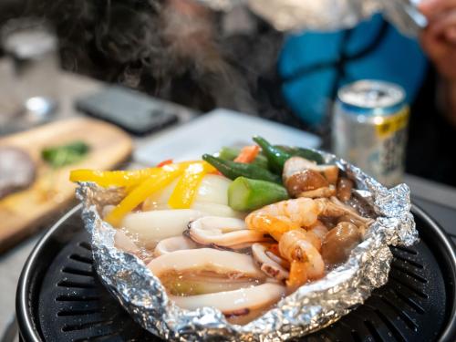 a plate of food with shrimp and vegetables in foil at Farm Garden Hotel in Numazu