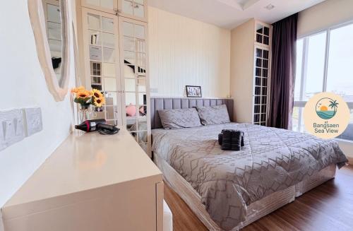 a bedroom with a bed and a counter with flowers on it at At Bangsaen in Ban Bang Saen (1)