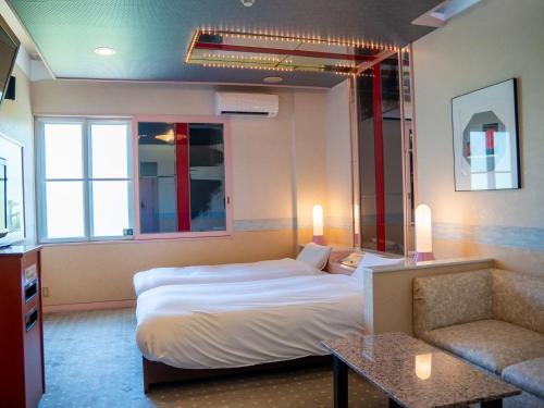 a hotel room with a bed and a couch at Farm Garden Hotel in Numazu