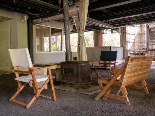 a room with a table and chairs and a wood stove at Farm Garden Hotel in Numazu