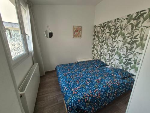 a small bedroom with a bed with a floral patterned wall at V17 Evalley, proche grands axes idéal PRO in Cambrai