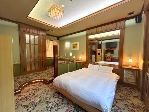 a bedroom with a large bed and a large mirror at Farm Garden Hotel in Numazu
