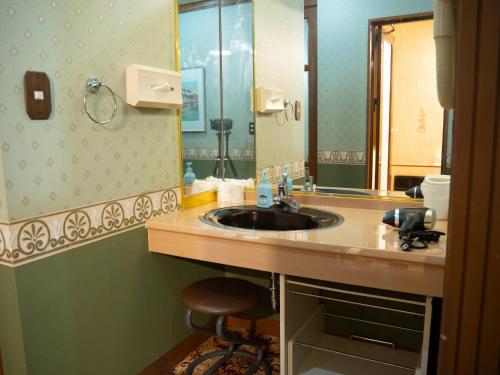 a bathroom with a sink and a mirror at Farm Garden Hotel in Numazu