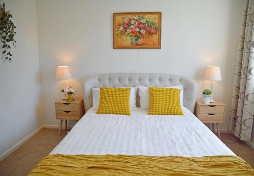 a bedroom with a white bed with yellow pillows at Gables Box hill Maraylya Two Level House 14ppl in Annangrove