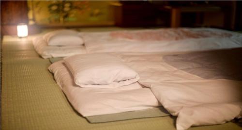 Rural house for rent - Vacation STAY 18282v في Susami: مجموعة من الأسرة البيضاء اصطفت في غرفة