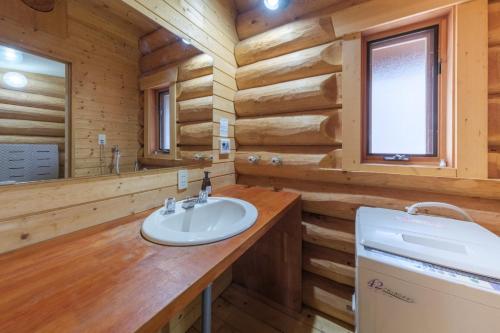 a bathroom in a log cabin with a sink and a mirror at Shakunagedaira Rental Cottage - Vacation STAY 18468v in Numajiri