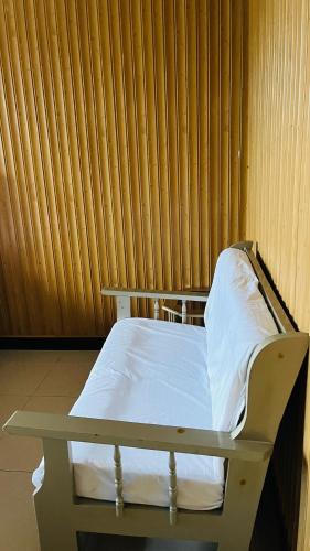 a bed in a room with a wooden wall at Velvet Pine Hotel in Abbottābād