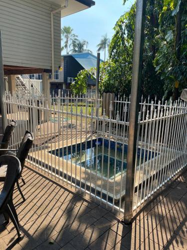 a fence on a deck with a swimming pool at Family Friendly With Inground Spa - Room To Enjoy in Nightcliff