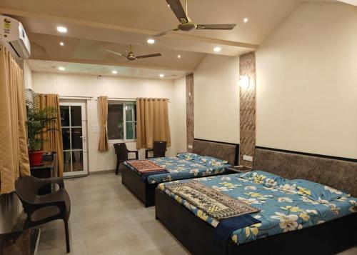 a bedroom with two beds and a table and chairs at Madhuson Palms in Karjat